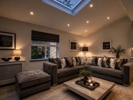 A living room featuring a sofa, coffee table, lamp, and window at Chowdene Lodge Estate
