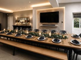 A dining room with a long table set for a meal at Chowdene Lodge Estate