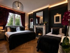 A bedroom with two beds and a fireplace at Chowdene Lodge Estate