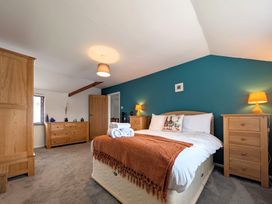 A bedroom with a bed and wooden furniture at The Old Barn near St Ives Rustic Charm Space, Lelant