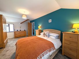 A bedroom with a bed and wooden furniture at The Old Barn near St Ives Rustic Charm Space, Lelant