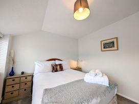 A bedroom with a bed and towels at The Old Barn near St Ives Rustic Charm Space Lelant