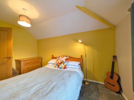 A bedroom with a bed and guitar at The Old Barn near St Ives Rustic Charm Space Lelant