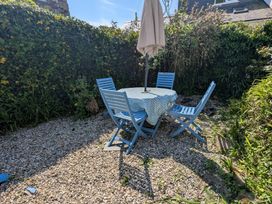 A garden with a table and chairs under an umbrella at The Old Barn near St Ives Rustic Charm Space Lelant