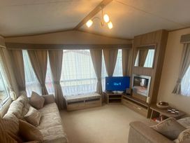 A living room with a television and sofa at The Old Barn in Manchester
