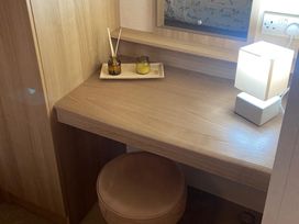 A desk with a lamp and scented oil in a dressing room at 
