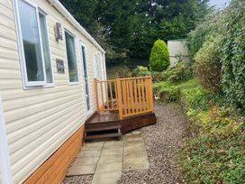 An outdoor area featuring a mobile home and a wooden deck at an unspecified location