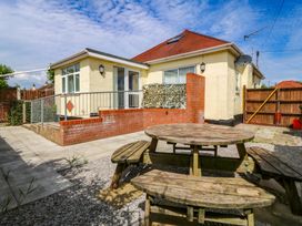 A garden with a picnic table and house at Seaside Bungalow in Rhyl