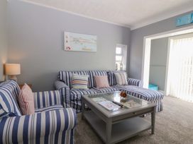 A living room with a striped sofa and coffee table at Seaside Bungalow in Rhyl