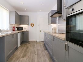 A kitchen with cabinets and appliances at Seaside Bungalow in Rhyl