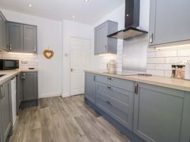 A kitchen with cabinets and appliances at Seaside Bungalow in Rhyl