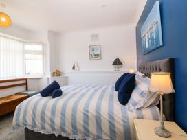 A bedroom with a bed and bedside lamp at Seaside Bungalow in Rhyl