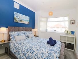 A bedroom with a bed and lamps at Seaside Bungalow in Rhyl