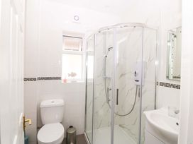 A bathroom with a shower toilet and sink at Seaside Bungalow in Rhyl