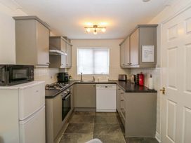 A kitchen with appliances and cabinetry at Robins Nest in Rhyl