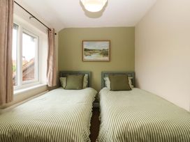 A bedroom with two beds and a window at Robins Nest in Rhyl