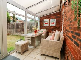 A conservatory with seating area and decor at Robins Nest in Rhyl