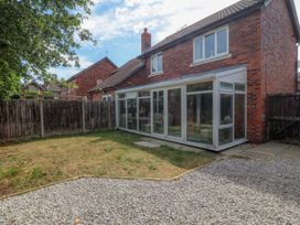 A garden with a conservatory and gravel area at Robins Nest in Rhyl
