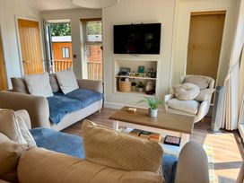 A living room with a sofa and table at Lakeside Retreat in Newton Abbot