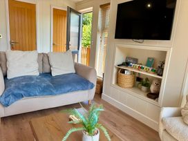 A living room with a sofa and a television at Lakeside Retreat in Newton Abbot