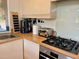 A kitchen with appliances including a sink, cooker, toaster, and coffee maker at Lakeside Retreat in Newton Abbot