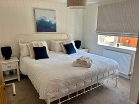 A bedroom with a bed and bedside tables at Lakeside Retreat in Newton Abbot