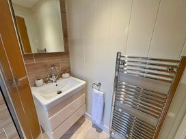 A bathroom with a sink and mirror at Lakeside Retreat in Newton Abbot