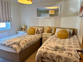 A bedroom with two beds and a lamp at Lakeside Retreat in Newton Abbot