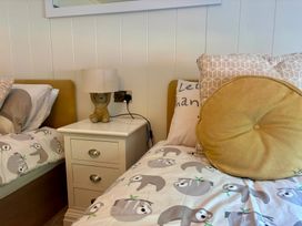 A bedroom with two beds and a nightstand at Lakeside Retreat in Newton Abbot