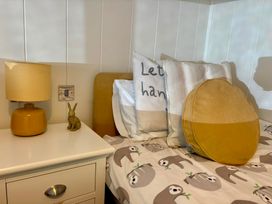A bedroom with a lamp and pillows on a bed at Lakeside Retreat in Newton Abbot