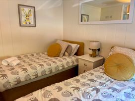A bedroom with twin beds and a nightstand at Lakeside Retreat in Newton Abbot