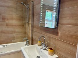A bathroom with a bathtub, sink, and shower at Lakeside Retreat in Newton Abbot