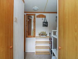 A hallway with a shelf and mirror at 10 Cater Gardens, Guildford