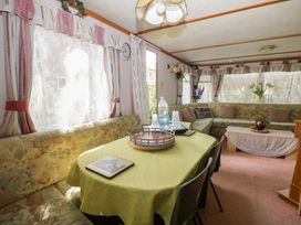 A living room with a table and seating area at 10 Cater Gardens Guildford