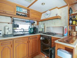 A kitchen with wooden cabinets and appliances at 10 Cater Gardens in Guildford
