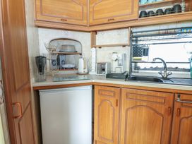 A kitchen with a refrigerator, sink, kettle, and coffee maker at 10 Cater Gardens in Guildford
