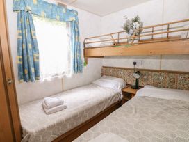 A bedroom with a bunk bed and a single bed at 10 Cater Gardens in Guildford