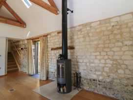 A living room with a wood stove and stone walls at Frome Gazey in Frampton