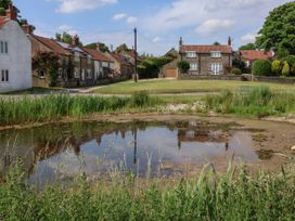 A pond with reflections and houses at Owl in Pickering