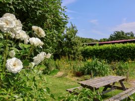A garden with white roses and a picnic table at Owl in Pickering