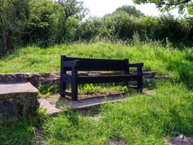 A bench surrounded by grass and stones at Owl in Pickering