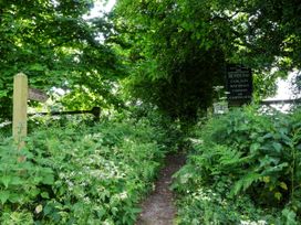 A pathway beside dense vegetation with signposts at Owl in Pickering