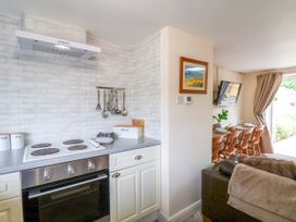 A kitchen with a stove and dining area at Owl in Pickering