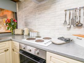 A kitchen with a stove and kettle at Owl in Pickering