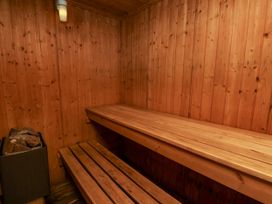 A sauna with wooden benches and heating stones at Owl in Pickering
