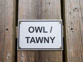 A sign displaying 'OWL / TAWNY' attached to wooden surface at Owl in Pickering