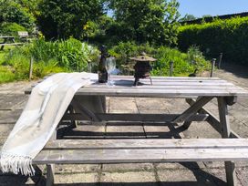 A garden table with a blanket, bottle, and glasses at Owl in Pickering