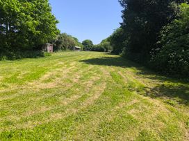 An outdoor grassy area with trees and wooden sheds at Owl in Pickering