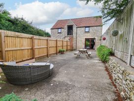A courtyard with a stone building and seating at Owl in Pickering