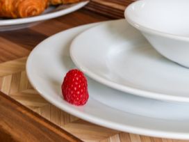 A plate and bowl with a raspberry on a wooden tray at Owl in Pickering
